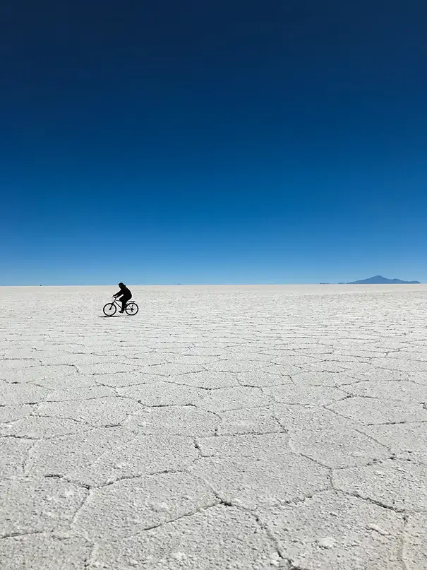Homem andando de bicicleta em deserto de sal